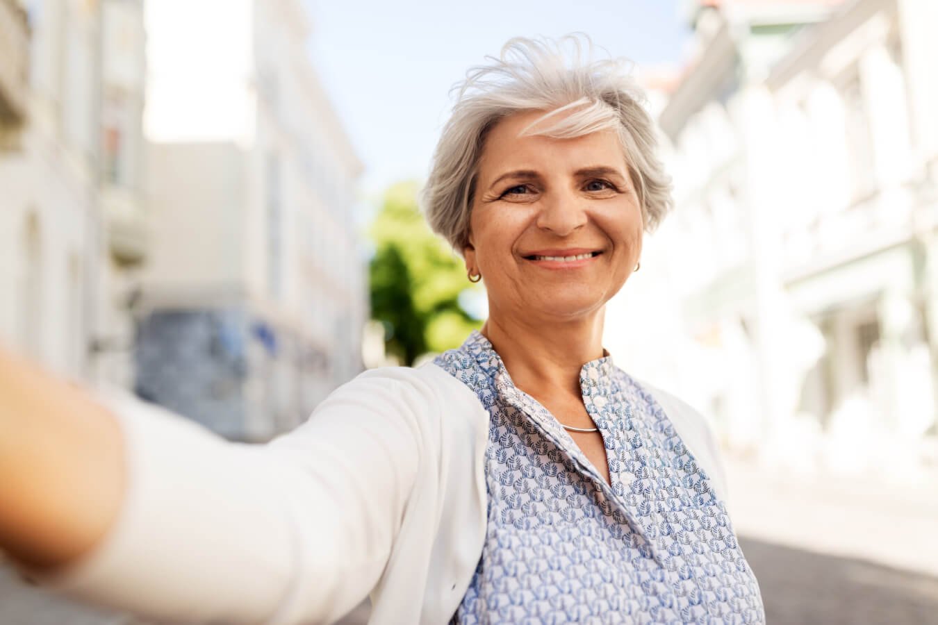 old age, retirement and people concept - happy senior woman taking selfie on city street in summer