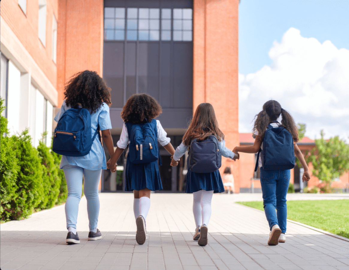 group of kids holding hands walking into school