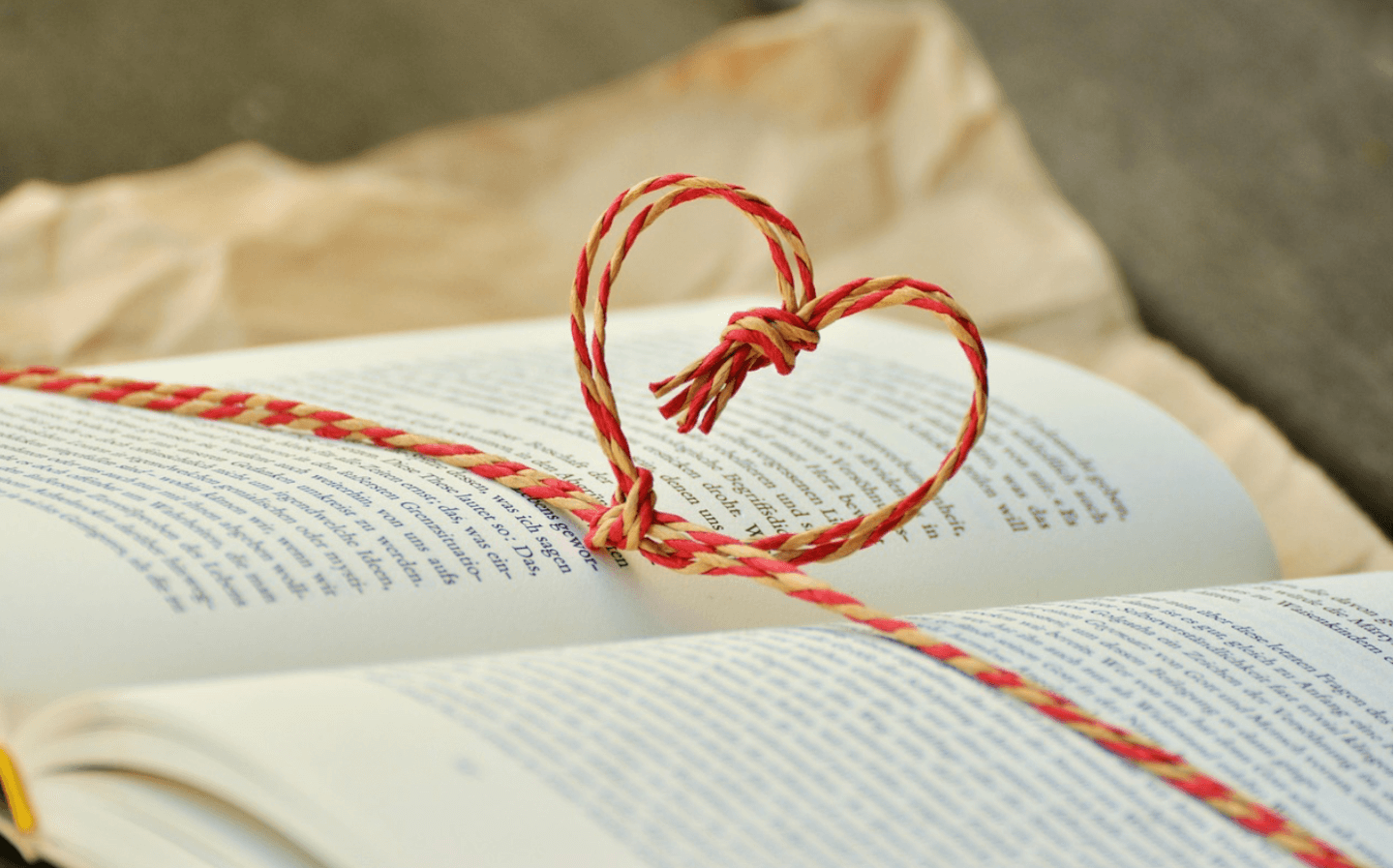 heart made of string over book pages