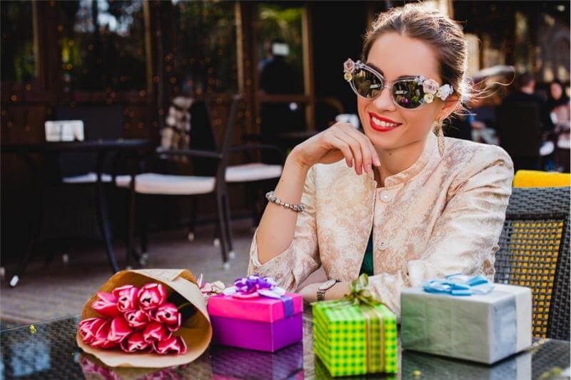 Trending Gifts For Women: Heartfelt Birthday Surprises 3 Woman with gifts and flowers outdoors
